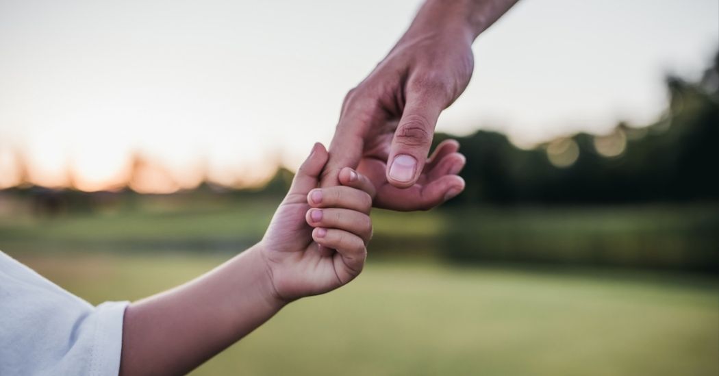 foster parent holding child's hand